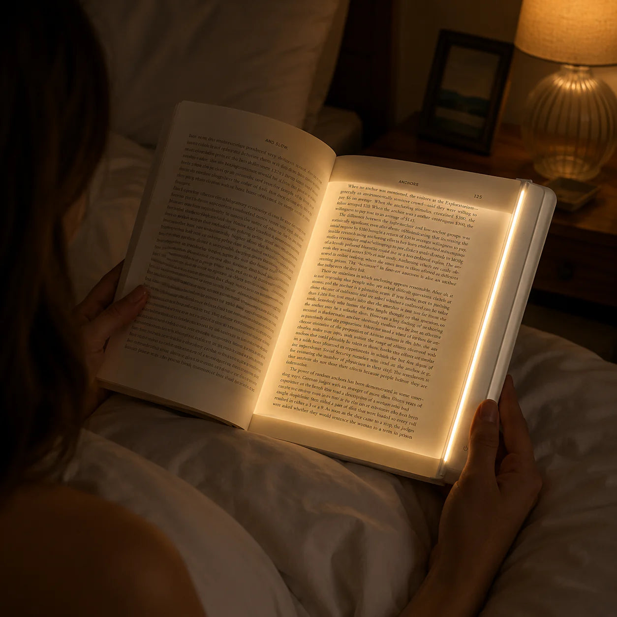 Woman reading in bed at night with LumiPage lighting her book